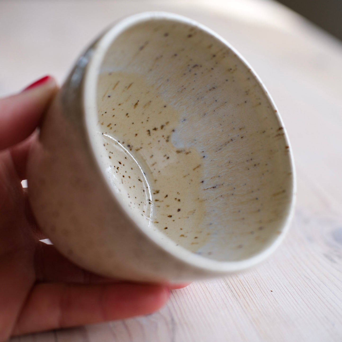 Handgjord kopp i beige glasyr, lavaprickig